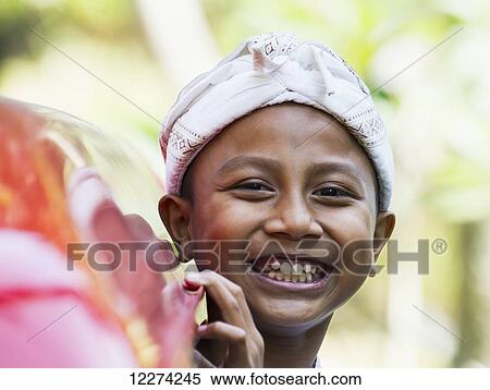 Stock Photography - Boy at a Ngaben or Cremation Ceremony, Klungkung, Bali, Indonesia. Fotosearch