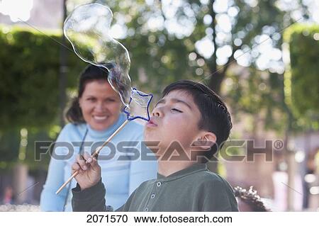 Stock Image - Boy Blowing Soap Bubbles At Plaza De Armas (Plaza De Los M. Fotosearch