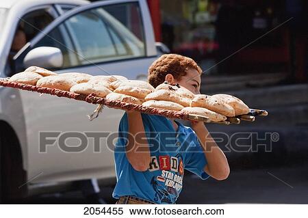 Stock Photography - Boy Carrying Pita Bread In The Souk, Aswan, Egypt. Fotosearch
