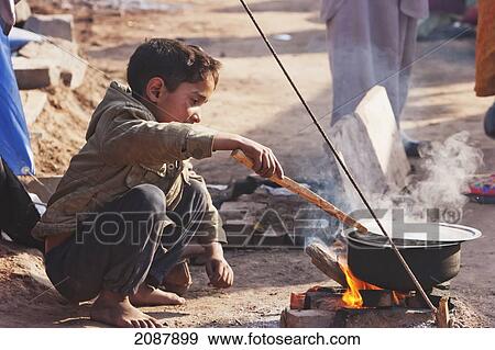 Stock Photo - Boy Cooking In A Relief Camp After The 8 October 2005 Earthquake, Muzaffarabad, Azad Kashmir, Pakistan. Fotosearch