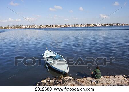 Boy Fishing By A Boat On The Shores Of The Rosetta Branch Of The Nile River, Rosetta (Rashid), Beheira, Egypt View Large Photo Image Stock Image - Boy Fishing By A Boat On The Shores Of The Rosetta Branch Of The Nile River, Rosetta (Rashid), Beheira, Egypt. Fotosearch