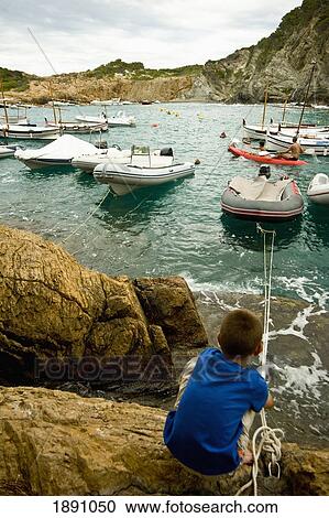 Stock Image - Boy Fishing On Sa Tuna Beach. Fotosearch