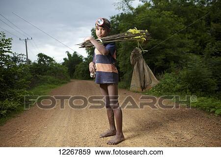 Stock Photo - Boy going fishing at dusk to help feed his family; Battambang, Cambodia. Fotosearch