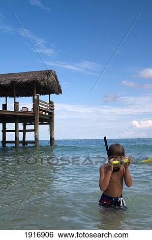 Stock Photograph - Boy In The Sea With Snorkel, Compass Point Resort Jetty In The Background. Fotosearch