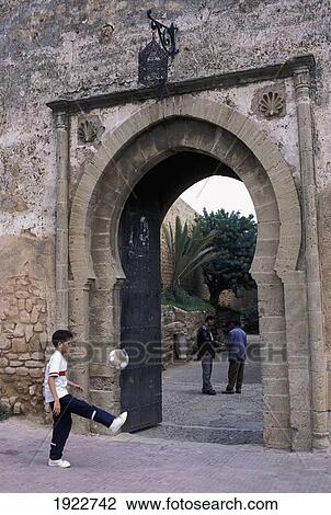 Boy Kicking Football By Gate, Kasbah Des Oudaias, Rabat, Morocco View Large Photo Image Stock Image - Boy Kicking Football By Gate, Kasbah Des Oudaias, Rabat, Morocco. Fotosearch