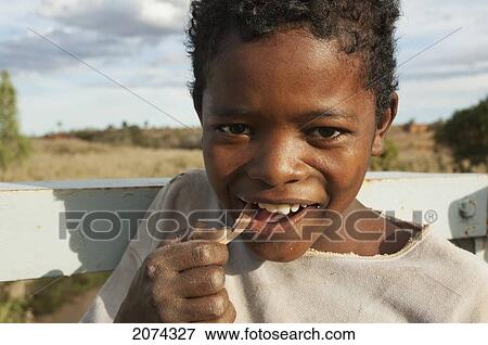 Boy On A Bridge Over The Maninday River Chewing A Piece Of Sugar Cane, Toliara Province, Madagascar View Large Photo Image Stock Photo - Boy On A Bridge Over The Maninday River Chewing A Piece Of Sugar Cane, Toliara Province, Madagascar. Fotosearch