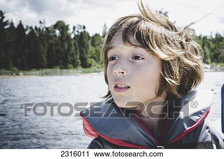 Boy On Lake Wearing Safety Vest And Looking In The Distance; Thetford Mines Quebec Canada View Large Photo Image Stock Image - Boy On Lake Wearing Safety Vest And Looking In The Distance; Thetford Mines Quebec Canada. Fotosearch