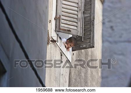 Stock Photo - Boy Peeking Out Of A Window, Split, Split-Dalmatia, Croatia. Fotosearch