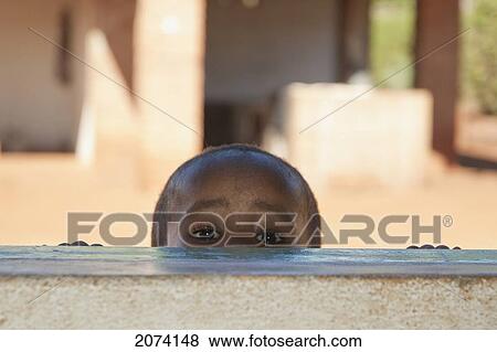 Boy Peeking Through A Window In Ambalavao, Fianarantsoa Province, Madagascar View Large Photo Image Stock Photo - Boy Peeking Through A Window In Ambalavao, Fianarantsoa Province, Madagascar. Fotosearch