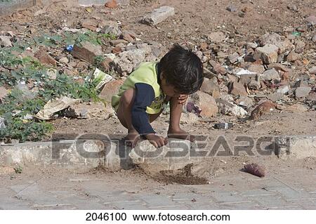 Stock Image - Boy Playing By Street, Samode, Rajasthan, India. Fotosearch
