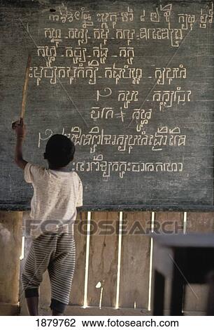Stock Image - Boy Pointing At Writing On A Blackboard In A Rural School. Fotosearch