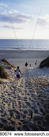 Boy Running Through Path In Sand Dunes Towards Sea View Large Photo Image Picture - Boy Running Through Path In Sand Dunes Towards Sea. Fotosearch