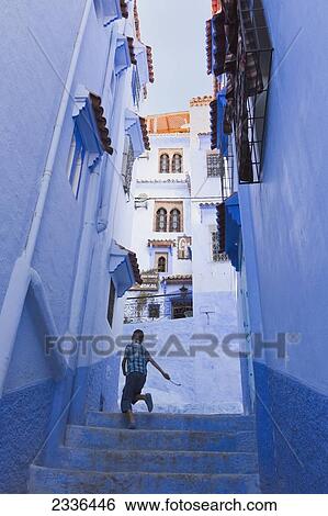 Boy Running Up Steps In Medina Beside Blue Buildings; Chefchaouen, Morocco View Large Photo Image Stock Photograph - Boy Running Up Steps In Medina Beside Blue Buildings; Chefchaouen, Morocco. Fotosearch