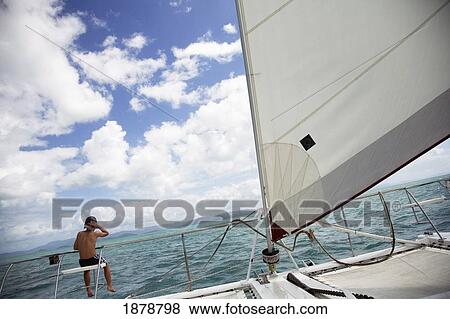 Stock Photo - Boy Sitting On Gang Plank On Sail Boat. Fotosearch