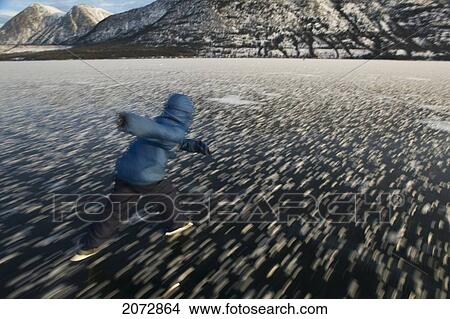 Boy Skating On Frozen Lake In Winter, Kusawa Lake Territorial Park, Yukon View Large Photo Image Picture - Boy Skating On Frozen Lake In Winter, Kusawa Lake Territorial Park, Yukon. Fotosearch