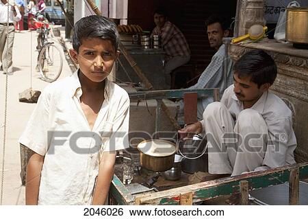 Stock Photograph - Boy Standing By A Man Cooking Chai (Tea), Nawalgarh, Rajasthan, India. Fotosearch