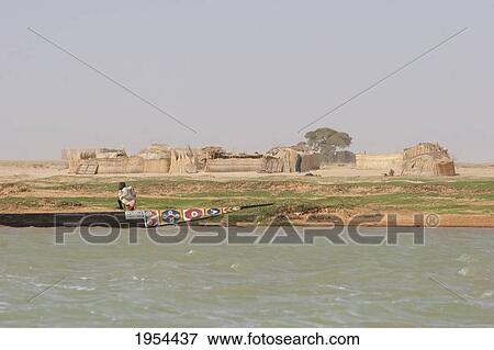 Boy standing in boat along the shores of the Niger River between Mopti and Lake Debo, Mali View Large Photo Image Stock Photo - Boy standing in boat along the shores of the Niger River between Mopti and Lake Debo, Mali. Fotosearch