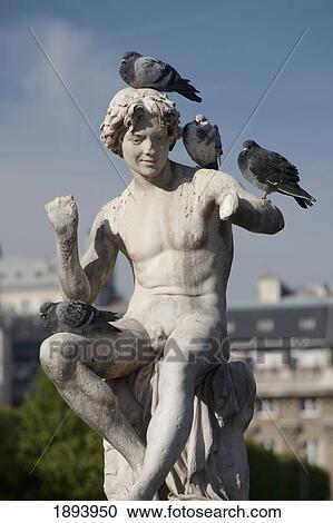 Stock Image - Boy Statue With Pigeons Sitting On It; Paris, France. Fotosearch