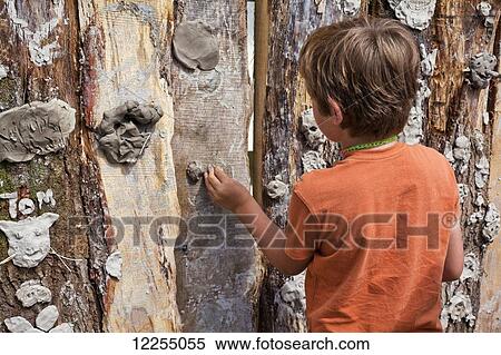 Boy working at a mud grafitti wall, music festival; Dorset, England View Large Photo Image Stock Photography - Boy working at a mud grafitti wall, music festival; Dorset, England. Fotosearch