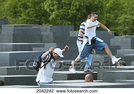 Stock Image - Boys Playing On The Stelae Of The Memorial To The Murdered Jews Of Europe, Berlin, Germany. Fotosearch