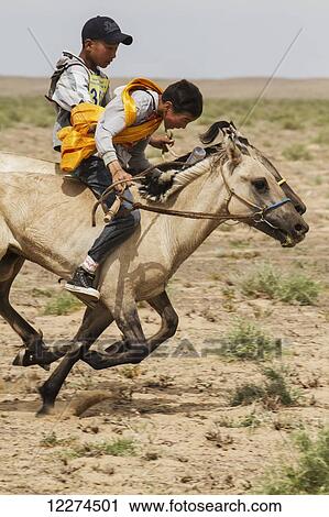 Stock Image - Boys riding horses in the Daaga (two-year old) horse race held during the Naadam Festival in Mandal Ovoo,? mnÃƒÆ’Ã‚Â·govi Province, Mongolia. Fotosearch