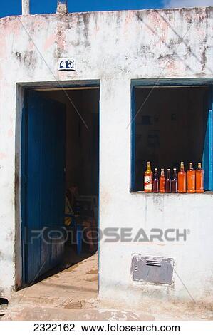 Stock Image - Brazil, Bahia, Itacare, Glass beverage bottles lined up in window sill. Fotosearch