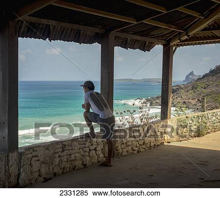 Stock Photography - Brazil, Pernambuco, Man enjoying view of Praia do Bodro; Fernando de Noronha. Fotosearch