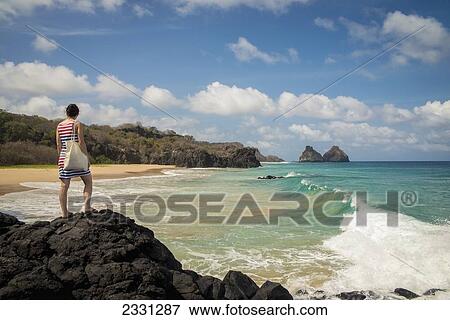Brazil, Pernambuco, Young woman enjoying view of Morro do Pico from Praia do Boldro; Fernando de Noronha View Large Photo Image Stock Photo - Brazil, Pernambuco, Young woman enjoying view of Morro do Pico from Praia do Boldro; Fernando de Noronha. Fotosearch