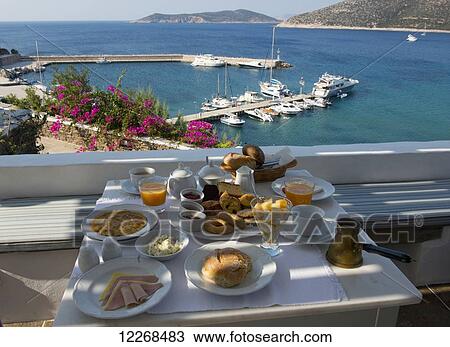 Stock Image - Breakfast including locally made pastries served on a terrace overlooking Platis Ghialos; Sifnos, Cyclades, Greek Islands, Greece. Fotosearch