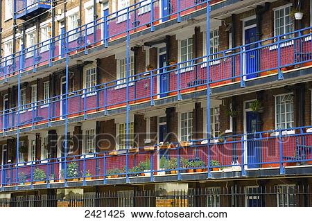 Brick building with blue railings and doors on the balconies and a red painted stripe on the lower half of the walls; London, England View Large Photo Image Stock Photography - Brick building with blue railings and doors on the balconies and a red painted stripe on the lower half of the walls; London, England. Fotosearch