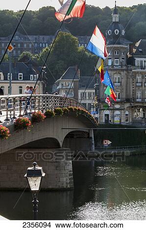 Picture - Bridge with flags crossing the river; Dinant, Ardennes, Belgium. Fotosearch