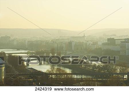 Stock Photo - Bridges crossing the Seine river at sunrise; Paris, France. Fotosearch