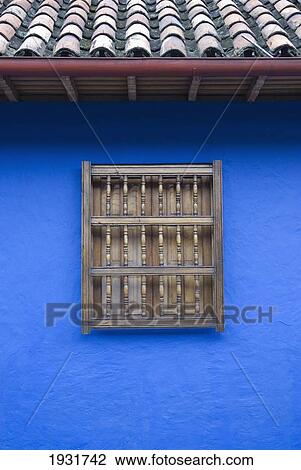 Stock Image - Bright blue house with window in La Candelaria, Bogota, Colombia., La Candelaria, Bogota, Colombia.. Fotosearch