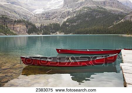 Bright red canoes on a tranquil alpine lake View Large Photo Image Stock Photography - Bright red canoes on a tranquil alpine lake. Fotosearch