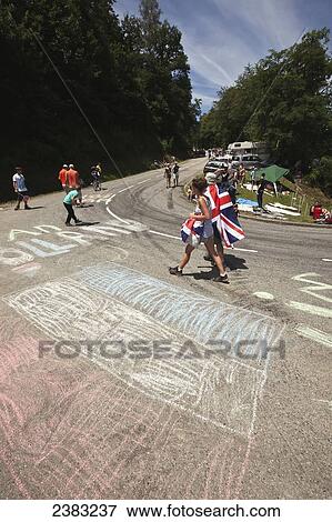 Stock Photo - British fans passing Dutch flags prior to cyclists riding up the steep mountain to Plateau de Beille, Tour de France; Pyrenees, France. Fotosearch