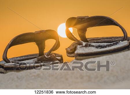 Brown leather sandals on the sand with a glowing orange sky and sun; Spain View Large Photo Image Stock Photograph - Brown leather sandals on the sand with a glowing orange sky and sun; Spain. Fotosearch
