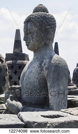 Buddha statue amidst the latticed stone stupas containing Buddha statues on the upper terrace, Borobudur Temple Compounds, Central Java, Indonesia View Large Photo Image Stock Photo - Buddha statue amidst the latticed stone stupas containing Buddha statues on the upper terrace, Borobudur Temple Compounds, Central Java, Indonesia. Fotosearch