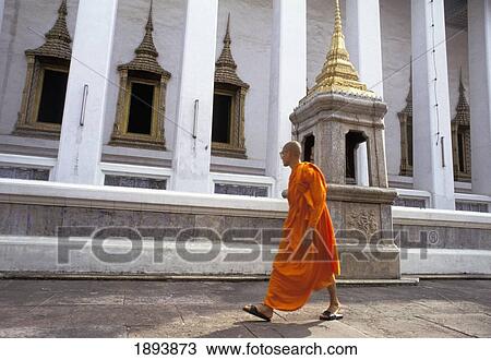 Stock Image - Buddhist Monk Walking Outside Temple. Fotosearch