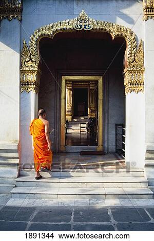 Picture - Buddhist Monk Walking Through Doorway Of Wat Benchamabophit. Fotosearch