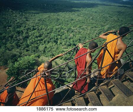 Stock Photography - Buddhist Monks Climb Steep Steps Of Sigiriya Rock Fortress, Sigiriya. Fotosearch