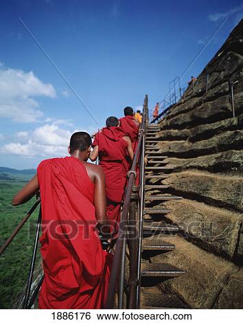 Stock Photograph - Buddhist Monks Climbing Steps Of Sigiriya Rock Fortress. Fotosearch