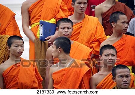 Stock Image - Buddhist monks in a temple wat; Luang Prabang, Laos. Fotosearch
