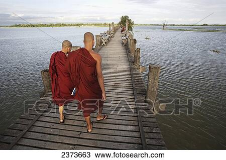 Buddhist monks walk across U Bein Bridge, made of Teak wood; Mandaly, Burma View Large Photo Image Stock Image - Buddhist monks walk across U Bein Bridge, made of Teak wood; Mandaly, Burma. Fotosearch