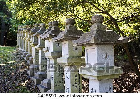 Stock Image - Buddhist structures in a row under a tree; Japan. Fotosearch