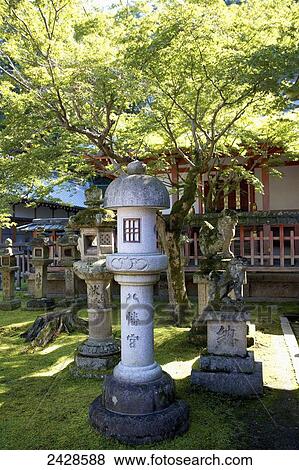 Stock Photo - Buddhist structures on the grass in front of a building; Japan. Fotosearch