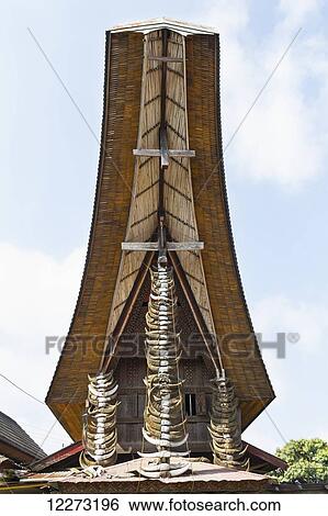 Stock Photograph - Buffalo horns hung in a vertical array on the front gable of a tongkonan, a traditional Torajan ancestral house in Rantepao, Toraja Land, South Sulawesi, Indonesia. Fotosearch