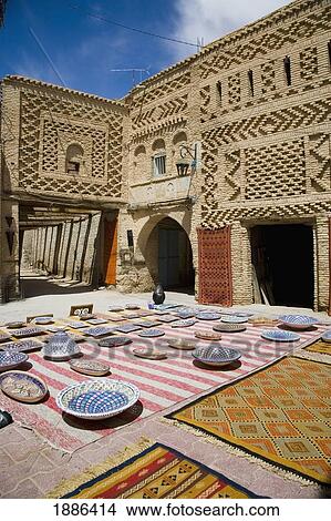 Picture - Building And Plates And Rugs On Display In A Small Square. Fotosearch