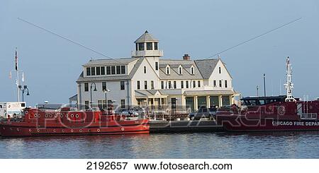 Stock Photo - Building And Red Boats On The Water; Chicago Illinois United States Of America. Fotosearch