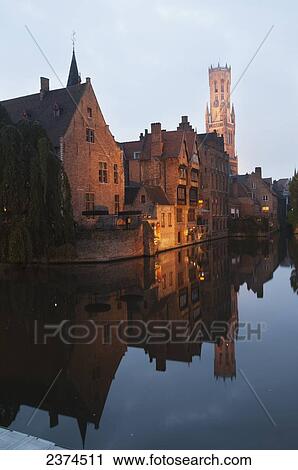 Stock Image - Buildings along the water illuminated at dusk; Bruges, Belgium. Fotosearch