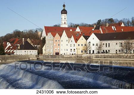 Stock Photograph - Buildings and a tower against a blue sky with water falling in tiers in the foreground; Landsberg, Bavaria, Germany. Fotosearch